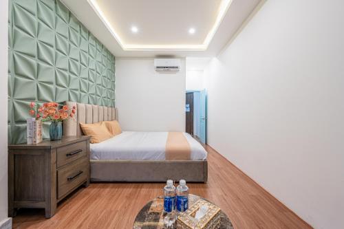 a bedroom with a bed and a table with bottles on it at Palas House By Cozrum in Ho Chi Minh City