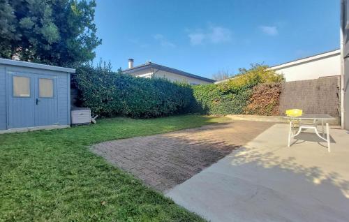 eine Terrasse mit einem Tisch im Garten in der Unterkunft 4 Bedroom Awesome Home In Royan in Royan