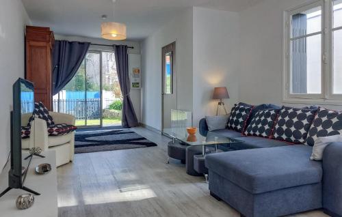 un salon avec un canapé bleu et une table dans l'établissement 4 Bedroom Awesome Home In Royan, à Royan