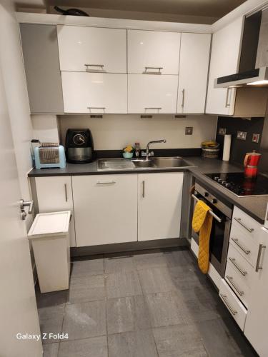 a kitchen with white cabinets and a sink at Tower Bridge - Saint Katherine's Dock in London