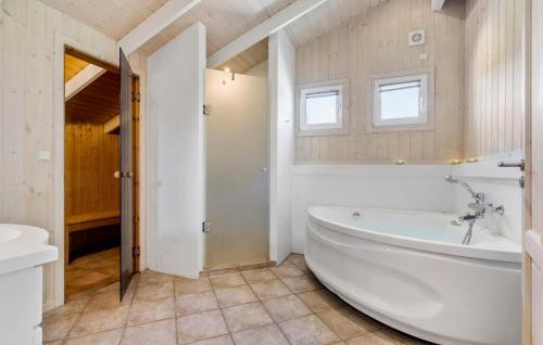 a white bathroom with a tub and a sink at Stunning Home In Ringkøbing With Sauna in Ringkøbing