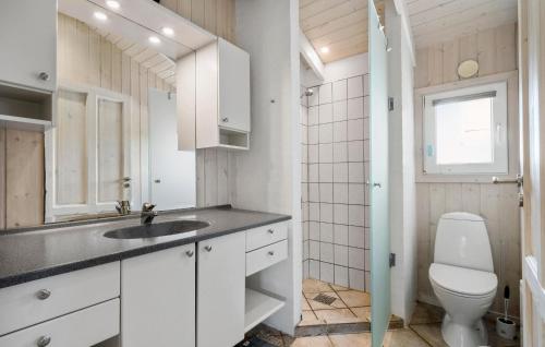 a white bathroom with a toilet and a sink at Stunning Home In Ringkøbing With Sauna in Ringkøbing