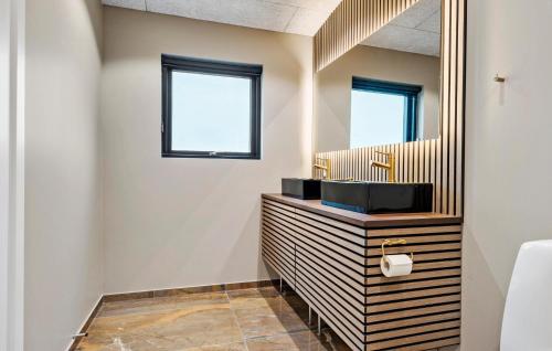 a bathroom with a sink and a mirror at 3 Bedroom Stunning Home In Løgstrup in Løgstrup