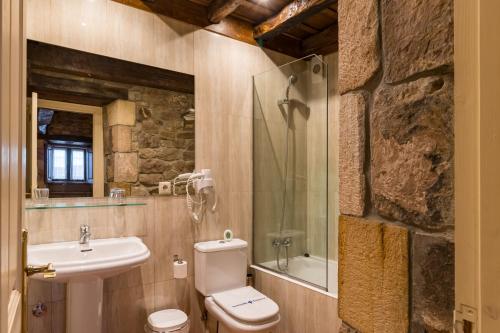 a bathroom with a white toilet and a sink at La Casona De Barrio in Barrio