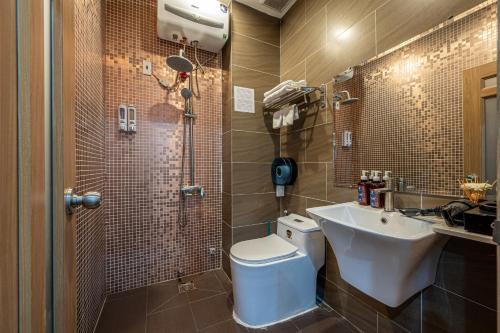 a bathroom with a white toilet and a sink at Palas House By Cozrum in Ho Chi Minh City