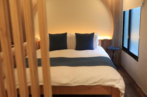 a bed with black and white sheets and a window at Green Inn Kaohsiung in Kaohsiung
