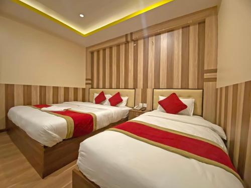 a hotel room with two beds with red pillows at Hotel Airport Holiday in Kathmandu