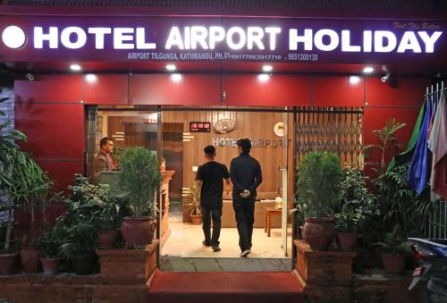 two men walking into a hotel airport lobby at Hotel Airport Holiday in Kathmandu