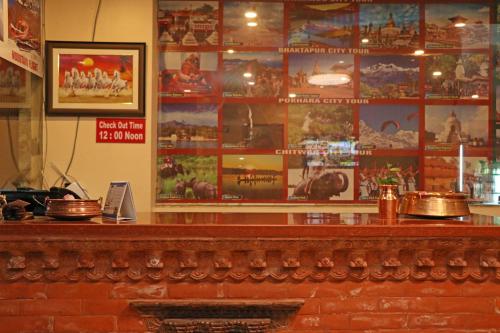 a bar in a restaurant with posters on the wall at Hotel Airport Holiday in Kathmandu