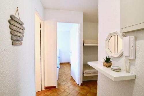 Cette chambre dispose d'un couloir avec un miroir et un lavabo. dans l'établissement CAPRI Appartement confort bord de mer, à Saint-Mandrier-sur-Mer