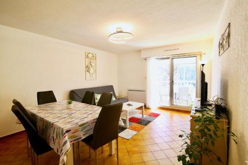 un salon avec une table et un canapé dans l'établissement CAPRI Appartement confort bord de mer, à Saint-Mandrier-sur-Mer