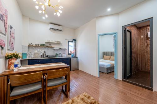 a kitchen and living room with a dining table and a bedroom at Palas House By Cozrum in Ho Chi Minh City