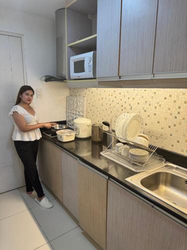 a woman standing in a kitchen preparing food at JT Tagaytay Suites in Tagaytay