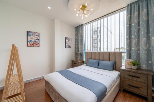 a bedroom with a bed and a large window at Palas House By Cozrum in Ho Chi Minh City