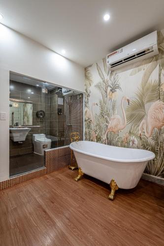 a bathroom with a large tub and a pink flamingo wallpaper at Palas House By Cozrum in Ho Chi Minh City