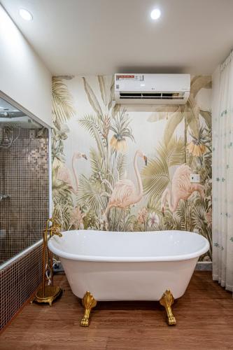 a bath tub in a bathroom with pink flamingos at Palas House By Cozrum in Ho Chi Minh City