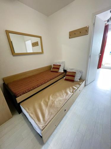 deux lits dans une chambre avec un miroir dans l'établissement LE GRAND BLEU-Fouc, au Barcarès