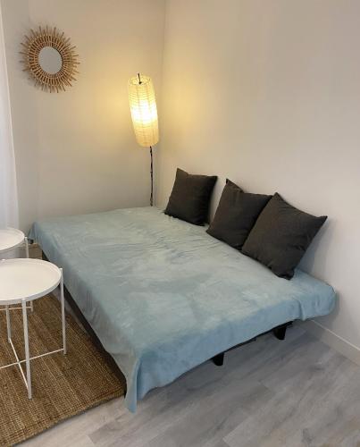 - une chambre avec un lit doté de draps bleus et d'une lampe dans l'établissement La Ciotat Chez Hugo confortable studio clim, wifi, parking, centre ville, commerces, port, plages à pieds, à La Ciotat