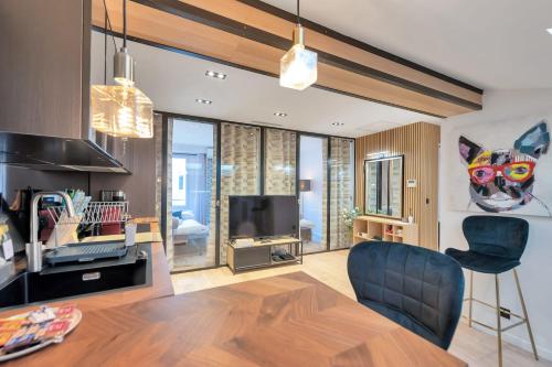 un salon avec un canapé et une télévision dans l'établissement LE NAPOLEON chic et moderne, l'endroit parfait au cœur de la Banane, à Cannes