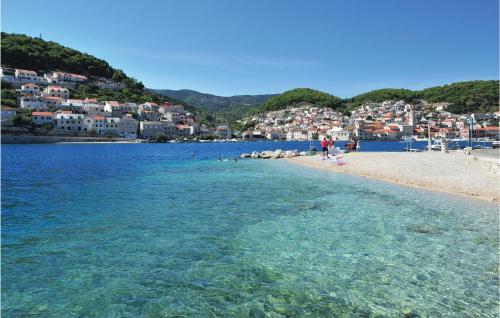 a beach with a group of people in the water at Lovely Home In Pucisca With Jacuzzi in Pučišća