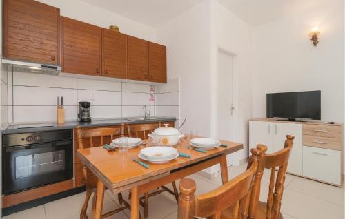 a kitchen with a wooden table with two chairs at Lovely Home In Pucisca With Jacuzzi in Pučišća