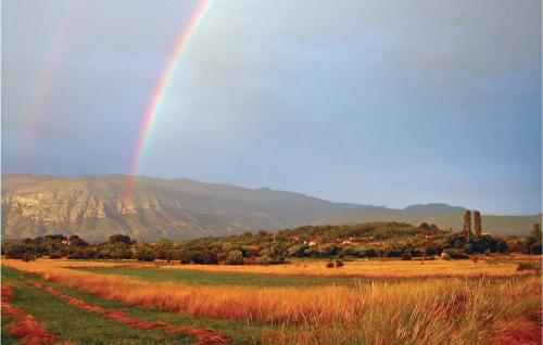 a rainbow in the sky over a field at Three-Bedroom Holiday Home In Neoric in Neorić