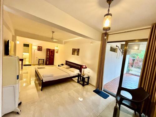 a large room with a bed and a window at Honeywood Holiday Homes in Mahabaleshwar