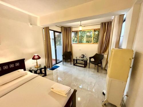 a bedroom with a bed and a living room at Honeywood Holiday Homes in Mahabaleshwar