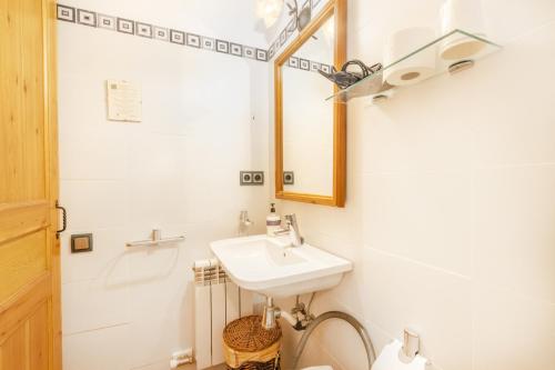 a bathroom with a sink and a toilet and a mirror at Casa Roca Sant Martí de Barcedana in Aransís