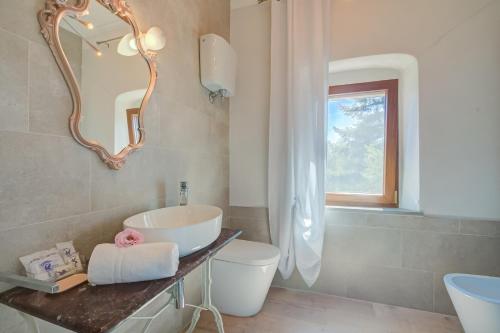 a bathroom with a sink and a toilet and a mirror at Relaxing Margherita Home Private Garden - Happy Rentals in Bucine