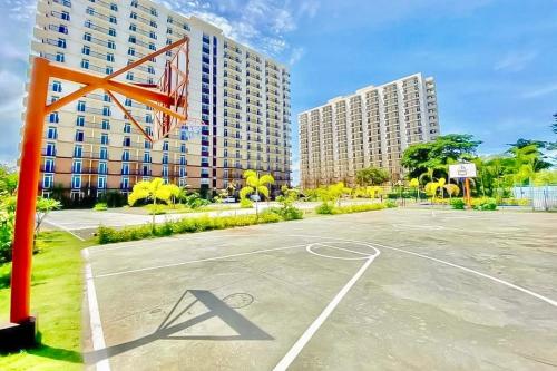 an empty basketball court in front of a tall building at Spacious Condo Unit with Balcony in Lo-oc
