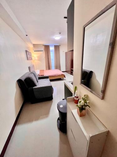 a living room with a couch and a mirror at Spacious Condo Unit with Balcony in Lo-oc