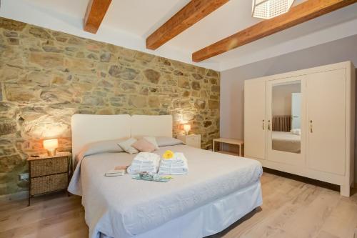a bedroom with a white bed in a stone wall at Relaxing Margherita Home Private Garden - Happy Rentals in Bucine