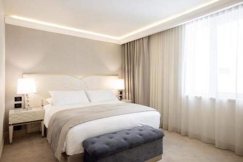 a bedroom with a large bed and a large window at Tresor Le Palais Timisoara, Curio Collection by Hilton in Timişoara