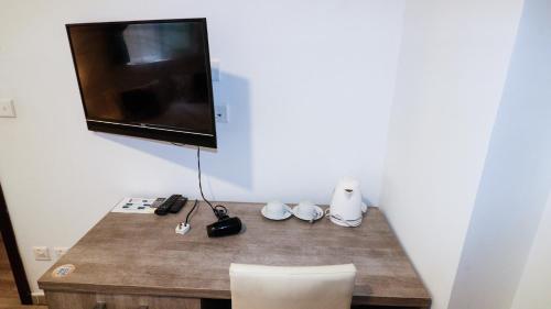 a room with a table with a television on a wall at Napoli Suites Studios Aparthotel in St Julian's