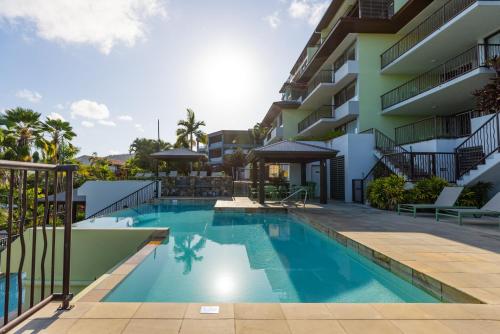 a swimming pool in front of a building at Aqua on the Edge in Airlie Beach