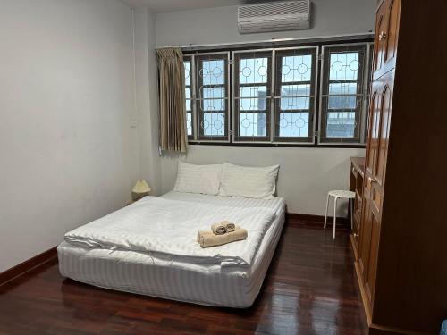 a bedroom with a bed with a pair of shoes on it at Kong Khong Homestay in Hat Yai