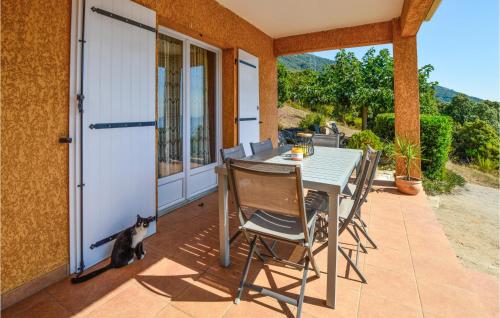 un chat assis à côté d'une table sur une terrasse dans l'établissement Nice Home In Casalabriva With Wifi, à Casalabriva