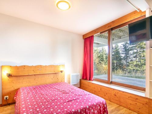 une chambre avec un lit et une grande fenêtre dans l'établissement V DU BACHAT AROLLES B02 Appt montagne 6 pers, à Chamrousse