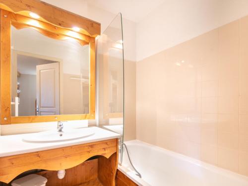 une salle de bain avec un lavabo, une baignoire et un miroir dans l'établissement V DU BACHAT AROLLES B02 Appt montagne 6 pers, à Chamrousse