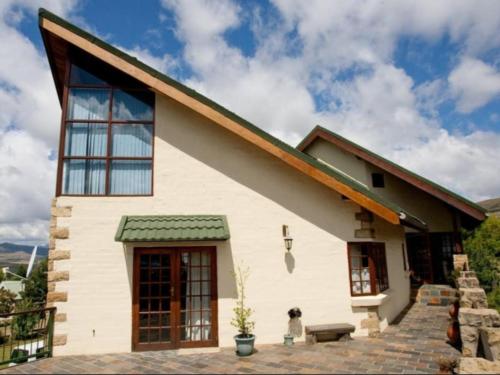 a dog is sitting outside of a house at Akzente in Clarens
