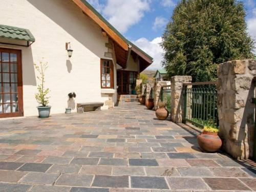 a patio with a stone walkway next to a building at Akzente in Clarens