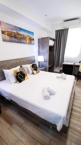 a bedroom with a large white bed in a room at Napoli Suites Studios Aparthotel in St Julian's