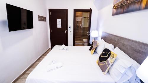 a bedroom with a white bed and a black door at Napoli Suites Studios Aparthotel in St Julian's