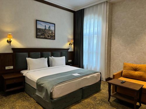 a hotel room with a bed and a chair at Midway Hotel Baku in Baku