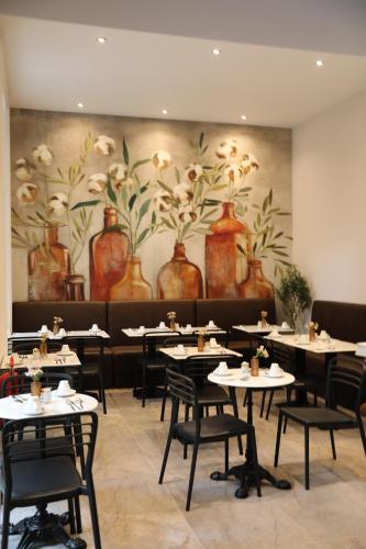 a dining room with tables and vases on the wall at Reem Hotel in London