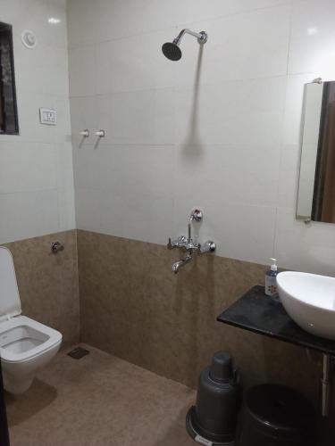 a bathroom with a toilet and a sink at Hotel Town Pride , Ganpatipule in Ganpatipule