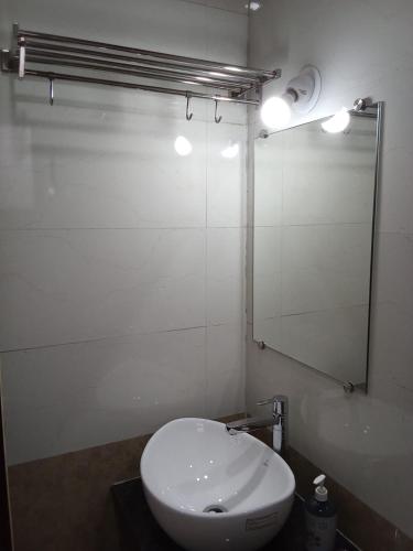 a bathroom with a white toilet and a mirror at Hotel Town Pride , Ganpatipule in Ganpatipule