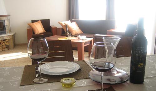 a table with two wine glasses and a bottle of wine at Amampuri Village in Pamporovo