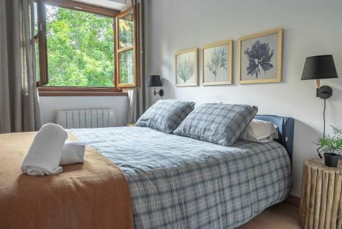 a bedroom with a bed with two pillows and a window at LOIRA CASA SANCHINES Dúplex de lujo en Benasque in Benasque